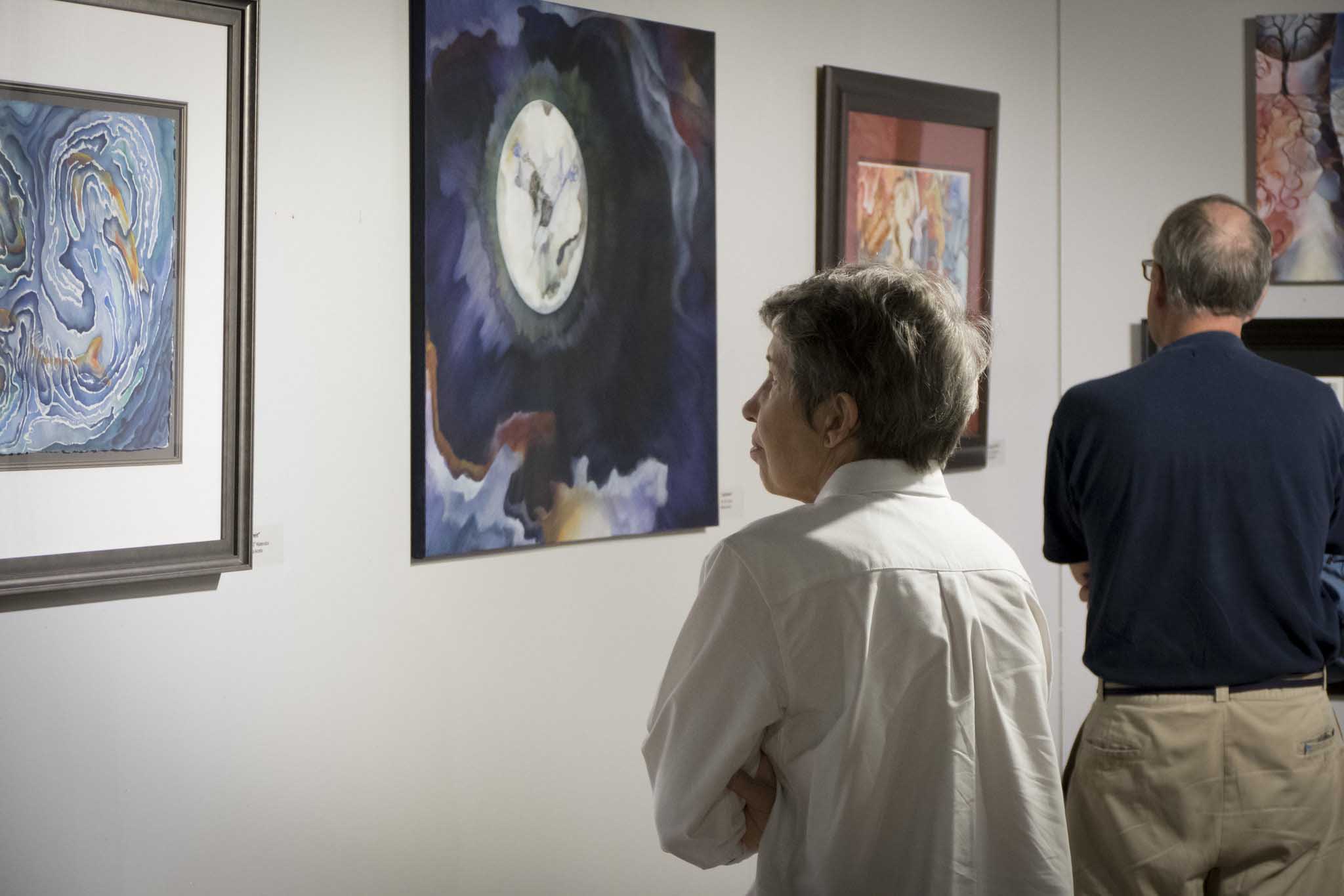 Visitor to gallery viewing artwork on wall
